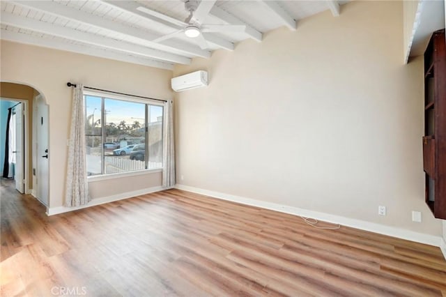 empty room with beamed ceiling, ceiling fan, a wall mounted AC, and light hardwood / wood-style floors