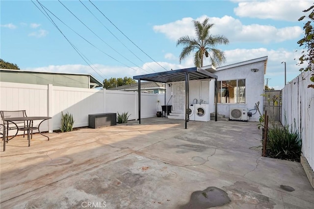 view of patio featuring washing machine and dryer and ac unit