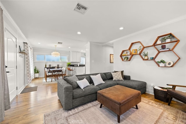 living room featuring ornamental molding and light hardwood / wood-style floors