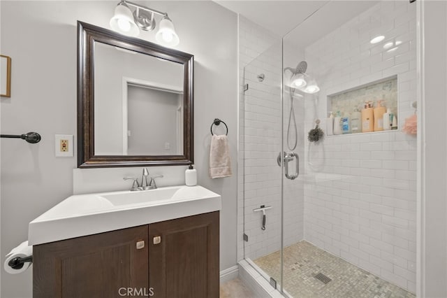 bathroom with a shower with door and vanity