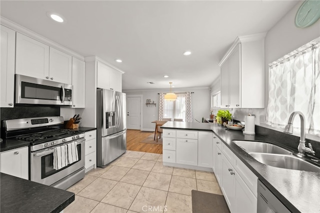 kitchen with white cabinetry, sink, light tile patterned floors, stainless steel appliances, and crown molding