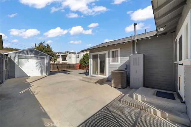 view of patio featuring a garage, an outdoor structure, and central air condition unit