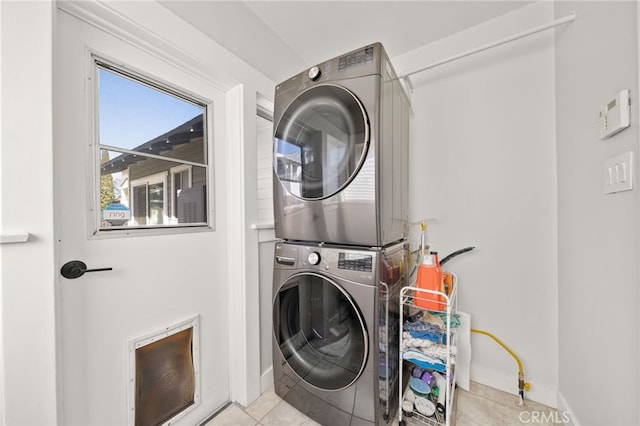 clothes washing area with stacked washer and dryer and light tile patterned flooring