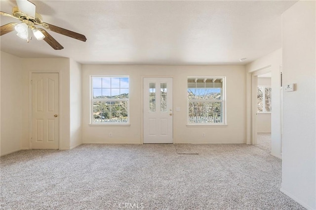 unfurnished room featuring light carpet and ceiling fan