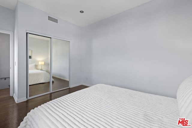 bedroom featuring dark hardwood / wood-style flooring and a closet