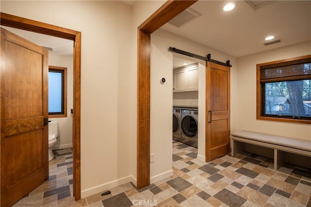 interior space featuring cabinets, washing machine and clothes dryer, and a barn door