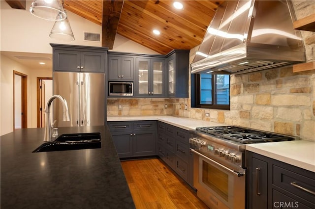 kitchen with sink, high end appliances, lofted ceiling with beams, island exhaust hood, and decorative backsplash