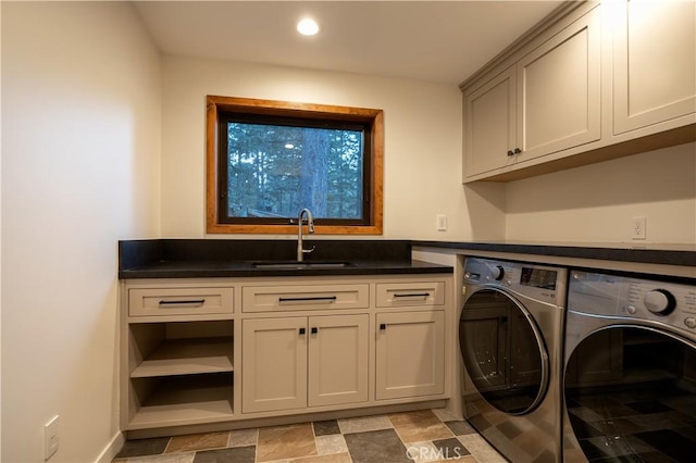 laundry area featuring cabinets, separate washer and dryer, and sink