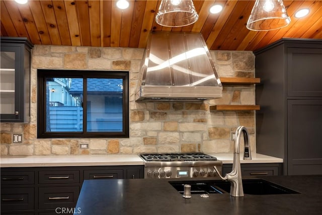 kitchen with pendant lighting, tasteful backsplash, sink, exhaust hood, and wood ceiling