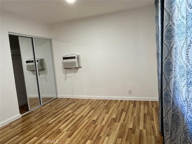 bathroom featuring hardwood / wood-style flooring and a wall mounted AC