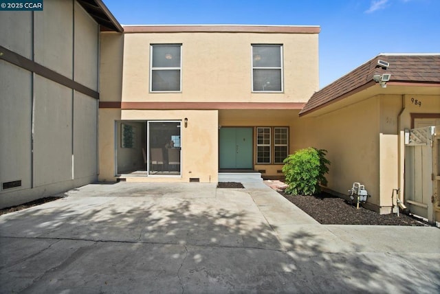 back of property with a patio