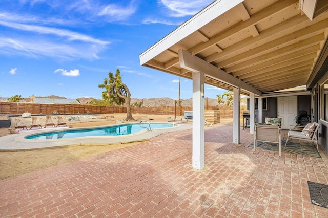 view of swimming pool with a mountain view and a patio