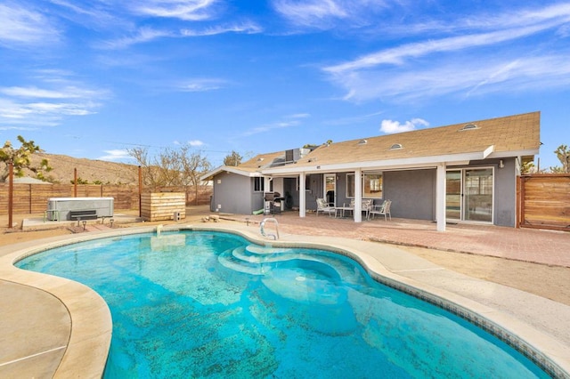 view of swimming pool featuring a hot tub, a patio, and grilling area