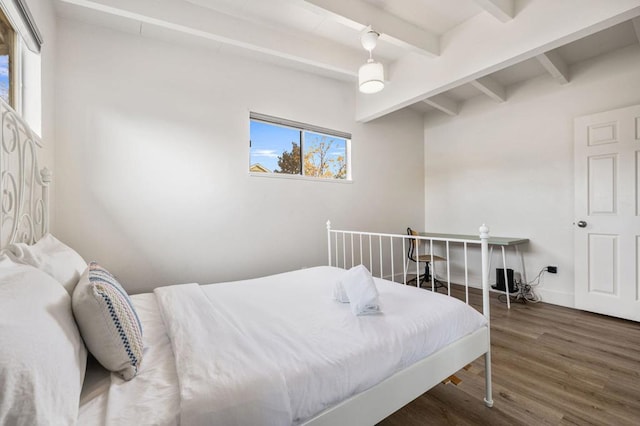 bedroom with dark wood-type flooring and beam ceiling