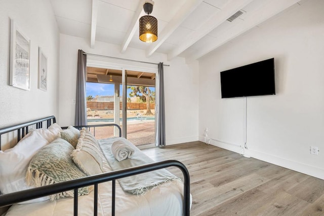 bedroom featuring light hardwood / wood-style flooring, vaulted ceiling with beams, and access to outside