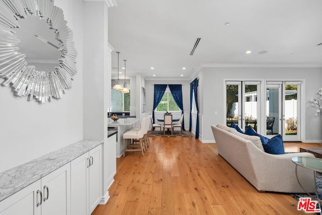 living room with ornamental molding and light hardwood / wood-style floors