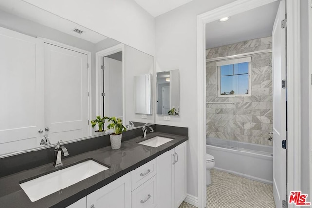 full bathroom featuring vanity, toilet, and tiled shower / bath