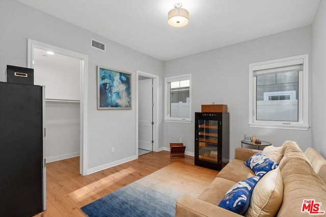 living room with wine cooler and light hardwood / wood-style floors