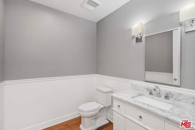 bathroom featuring vanity, toilet, and wood-type flooring