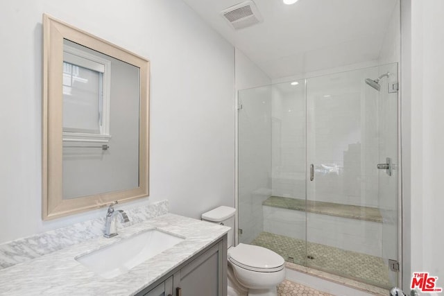 bathroom featuring vanity, an enclosed shower, and toilet