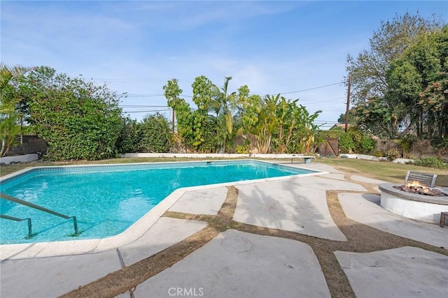 view of swimming pool featuring a patio and a fire pit