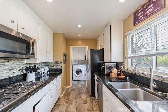 kitchen featuring stainless steel appliances, sink, white cabinets, and dark stone counters