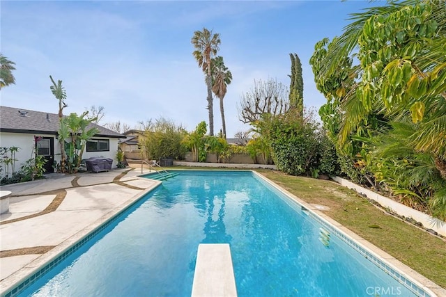 view of pool with a diving board and a patio