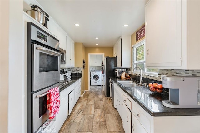 kitchen with tasteful backsplash, washer / dryer, white cabinets, and appliances with stainless steel finishes