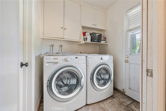 clothes washing area with cabinets and washer and dryer