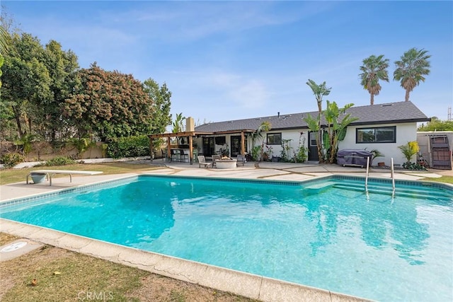 view of swimming pool with a diving board and a patio area