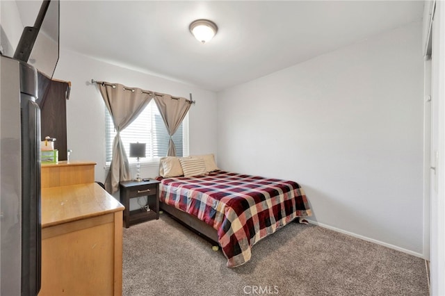 bedroom featuring stainless steel fridge and carpet