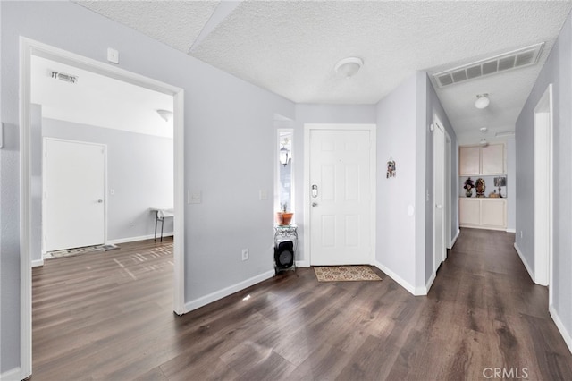 entryway with dark hardwood / wood-style floors and a textured ceiling