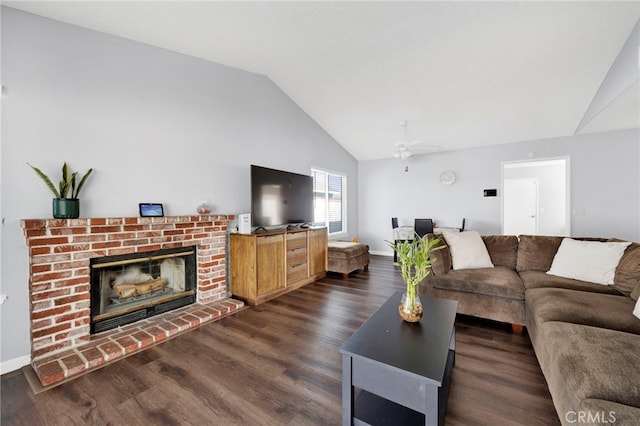 living room featuring vaulted ceiling, dark hardwood / wood-style floors, ceiling fan, and a fireplace