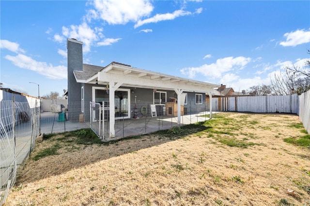 back of property with a yard and a patio area