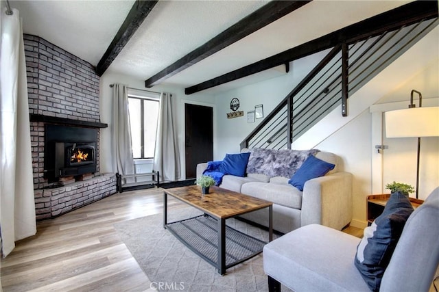 living room featuring beamed ceiling and light hardwood / wood-style floors