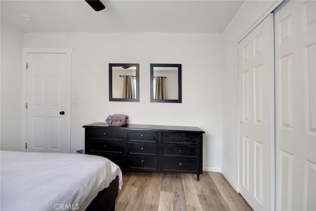 bedroom featuring light hardwood / wood-style floors, a closet, and ceiling fan