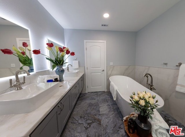 bathroom featuring vanity, tile walls, and a bathtub