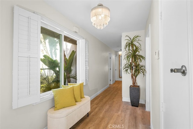 corridor with an inviting chandelier and hardwood / wood-style floors