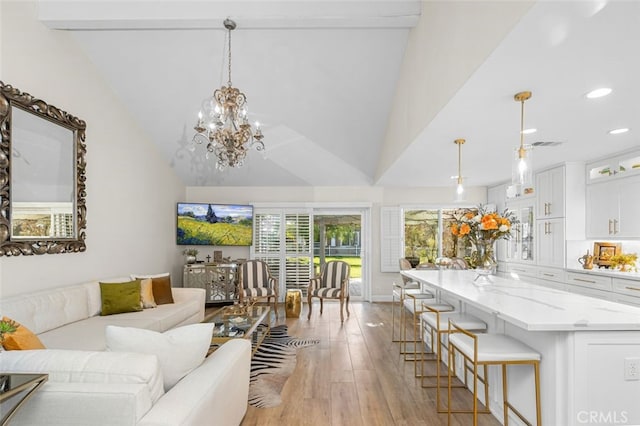 living room featuring high vaulted ceiling and light wood-type flooring