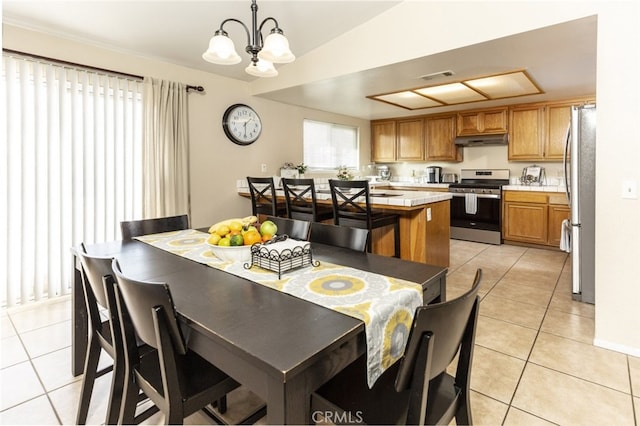 dining area featuring vaulted ceiling, light tile patterned floors, and an inviting chandelier