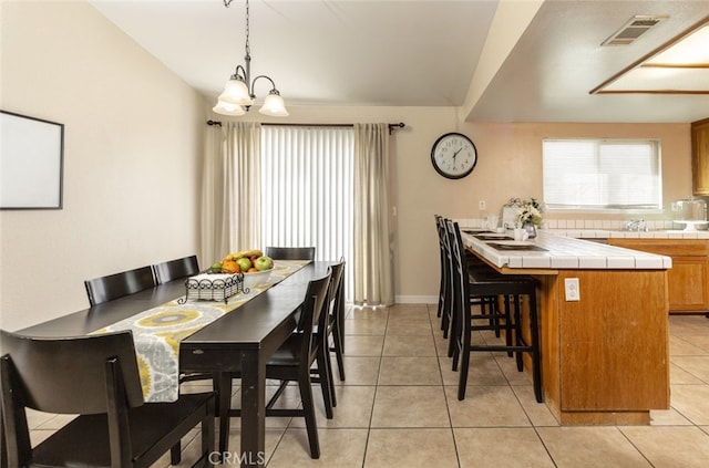 dining area featuring light tile patterned floors and a chandelier