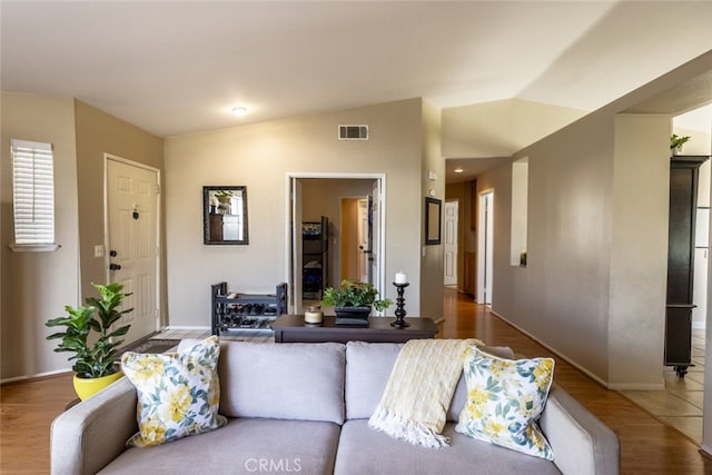 living room featuring vaulted ceiling and hardwood / wood-style floors