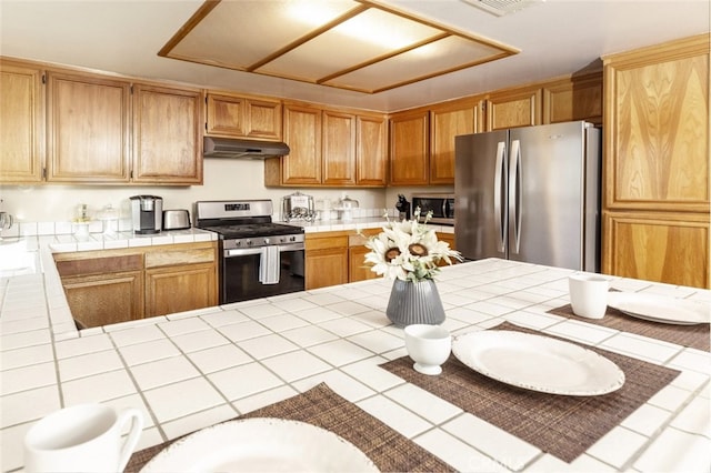 kitchen with appliances with stainless steel finishes and tile counters