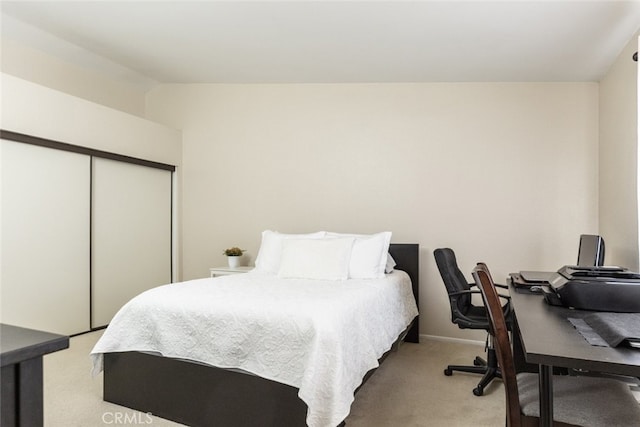 bedroom featuring vaulted ceiling, light colored carpet, and a closet