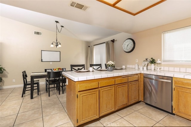 kitchen with pendant lighting, dishwasher, tile counters, light tile patterned flooring, and kitchen peninsula