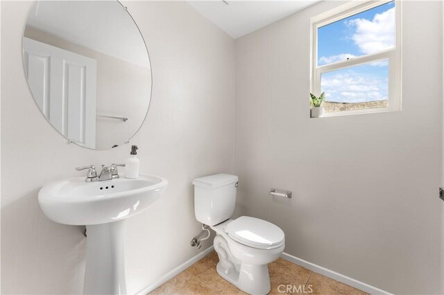 bathroom with sink, toilet, and tile patterned flooring