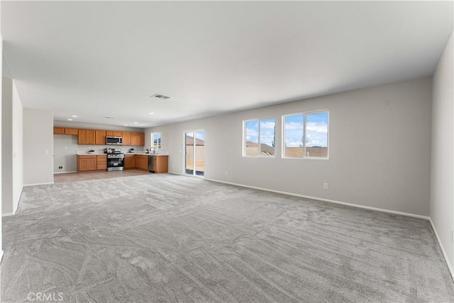 unfurnished living room featuring light carpet