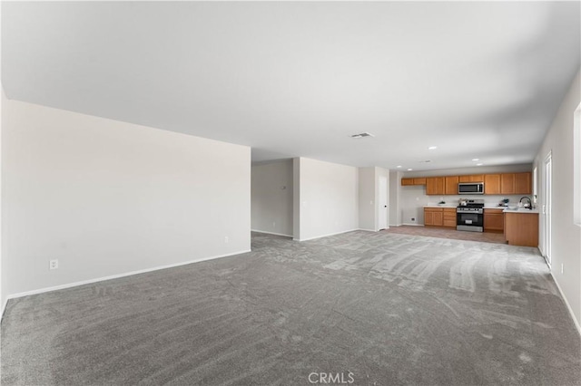 unfurnished living room featuring sink and light colored carpet