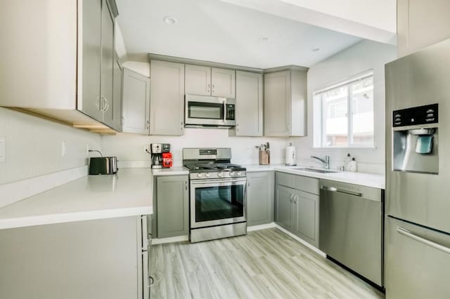 kitchen featuring light hardwood / wood-style flooring, sink, gray cabinets, and appliances with stainless steel finishes