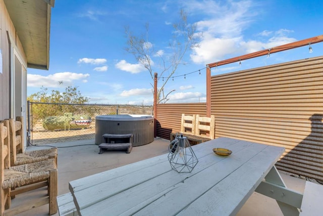 deck featuring a hot tub, a patio, and central AC